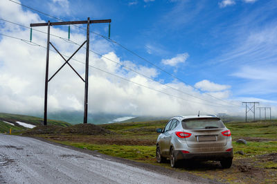 Silver bronze suv in full sloppy condition park the car on the side of a country road in iceland