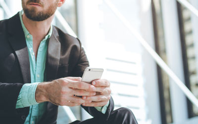 Midsection of man using mobile phone
