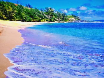 Scenic view of beach against blue sky