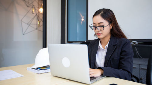 Businesswoman using laptop at desk in office