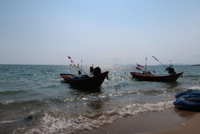 People on boat in sea against sky