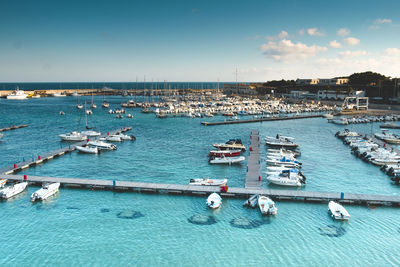 Boats in swimming pool by sea against sky