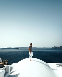 Man standing in sea against clear sky