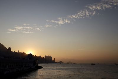 Scenic view of sea and buildings against sky during sunset