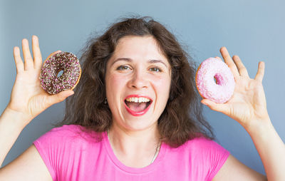 Portrait of woman holding pink food