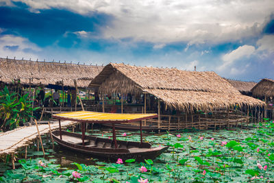 House by pond against sky