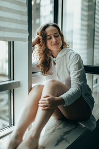 Portrait of young woman sitting at home