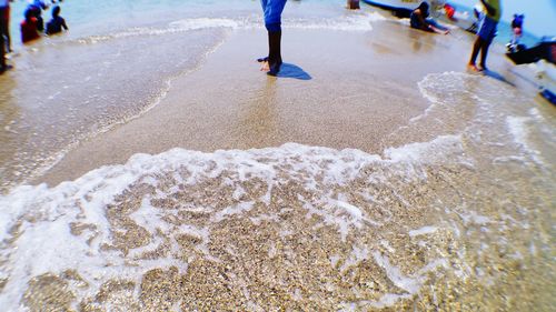 Low section of people standing on beach