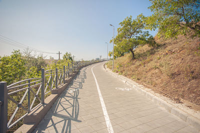 Walking path with bikeway and fence goes up the hill in the park