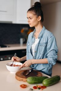 Young woman having food at home