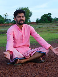 Portrait of young man lying on field