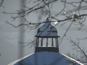 Traditional windmill against sky during winter