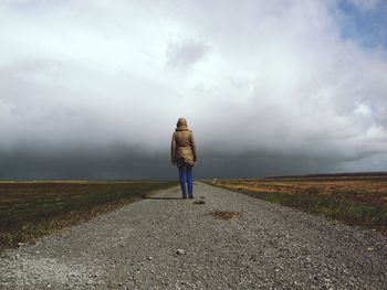 Rear view of woman on road against sky