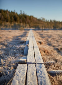 Surface level of railroad tracks on field against sky