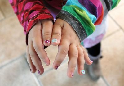 Midsection of decoratet nails on a hand of a baby girl