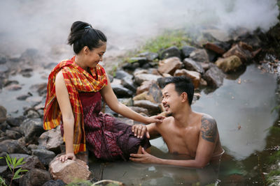 Full length of man and woman standing on rock