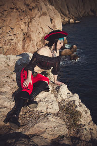 Portrait of a pirate woman at the beach. in anticipation of a pirate ship