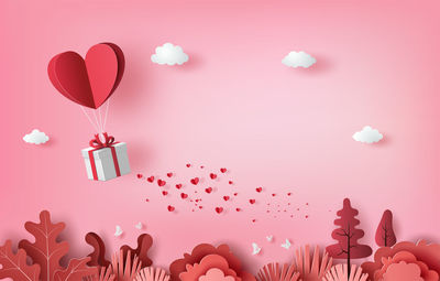 Heart shape with pink balloons against gray background