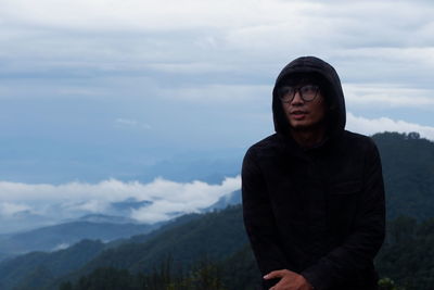 Man standing on mountain against sky