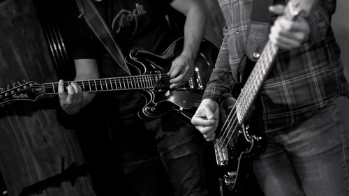 Midsection of man playing guitar