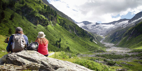 Rear view of couple sitting on mountain