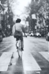 Blurred motion of people riding bicycle on city street