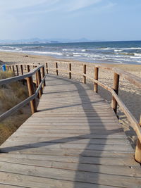 Wooden posts on beach against sky