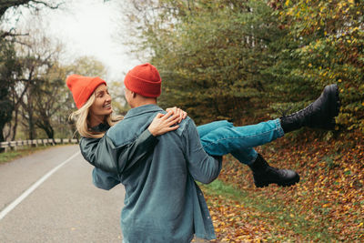 Young loving couple are fooling around outside.