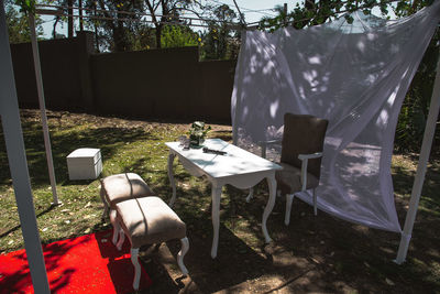 Empty chairs and table in yard