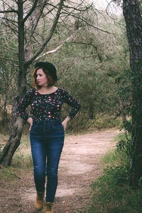 Full length of woman standing in forest