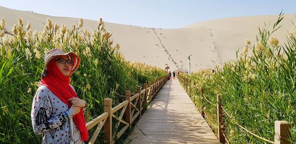 Portrait of woman amidst plants on land