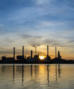 Scenic view of factory against sky during sunset