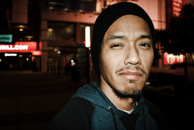 Portrait of young man in city at night