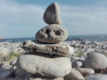 Stack of stones on beach against sky