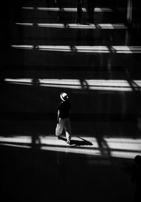 Full length rear view of woman walking on footpath