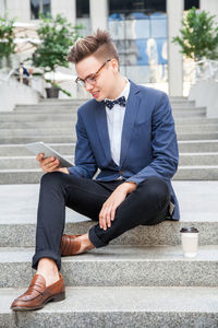 Full length of young man using mobile phone