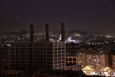 Illuminated cityscape against sky at night