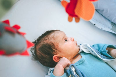 Portrait of cute baby girl lying on sofa