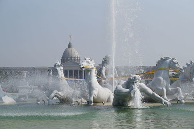 Water splashing in fountain against clear sky