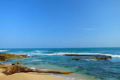 View of calm beach against blue sky