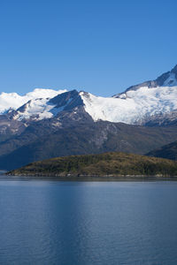 Scenic view of snowcapped mountains against blue sky