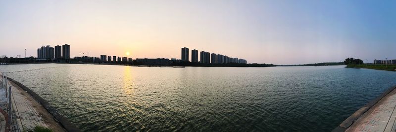 View of city at waterfront during sunset