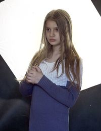 Portrait of girl standing against wall