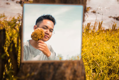 Portrait of man holding ice cream against plants