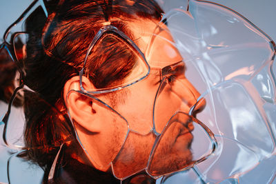 Close-up portrait of man behind glass