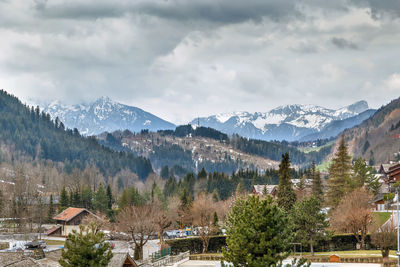 Scenic view of townscape by mountains against sky