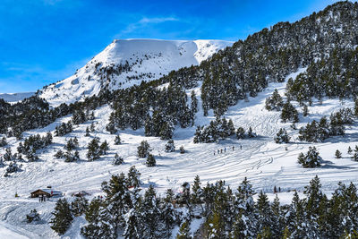 Beautiful winter scenery, mountains and forest covered in snow, people hiking in andorra
