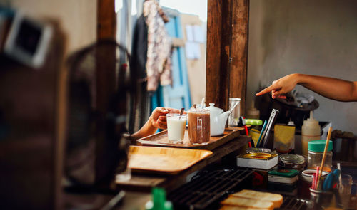 Midsection of woman holding drink on table