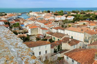 High angle view of townscape by sea against sky