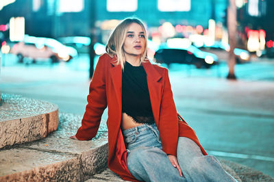 Portrait of young woman sitting outdoors